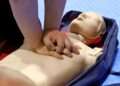 Someone demonstrates CPR on a CPR Manikin