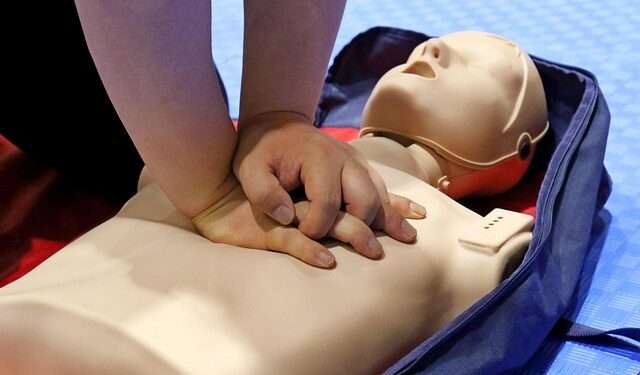 Someone demonstrates CPR on a CPR Manikin