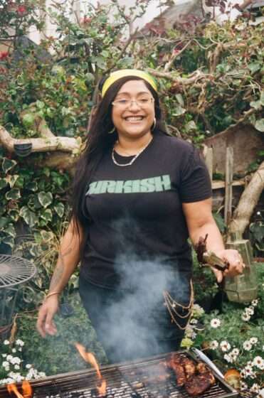 A woman stood in front of a grill wearing a 'Jurkish' top