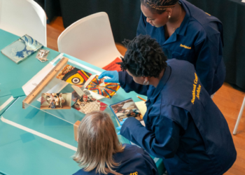 Volunteers at the Southbank Centre gather round a table, working on archiving.