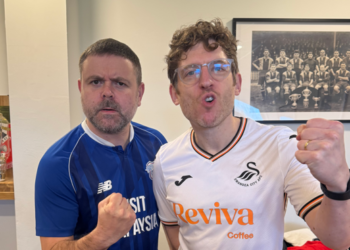 Two men cheer in football kits